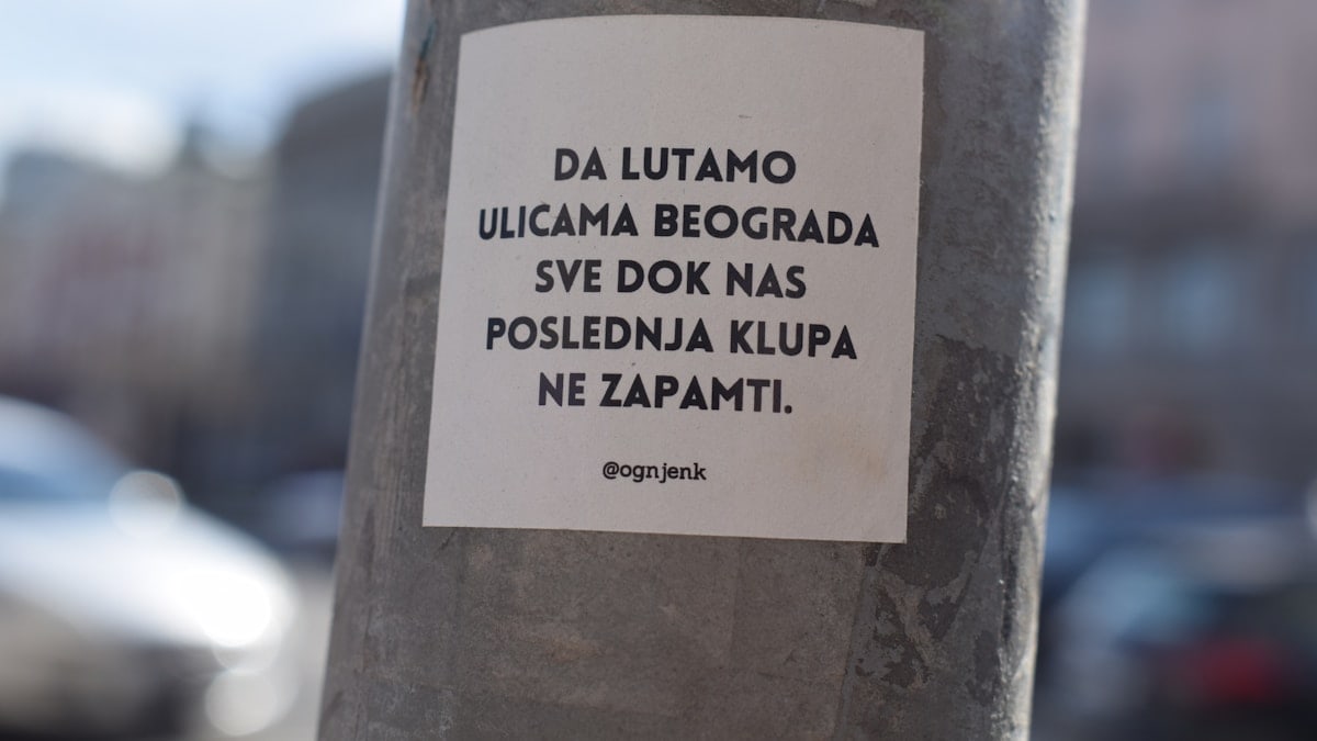 a sticker on a pole on a city street